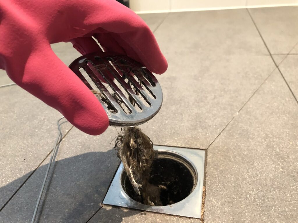 clogged drain being unclogged by plumber